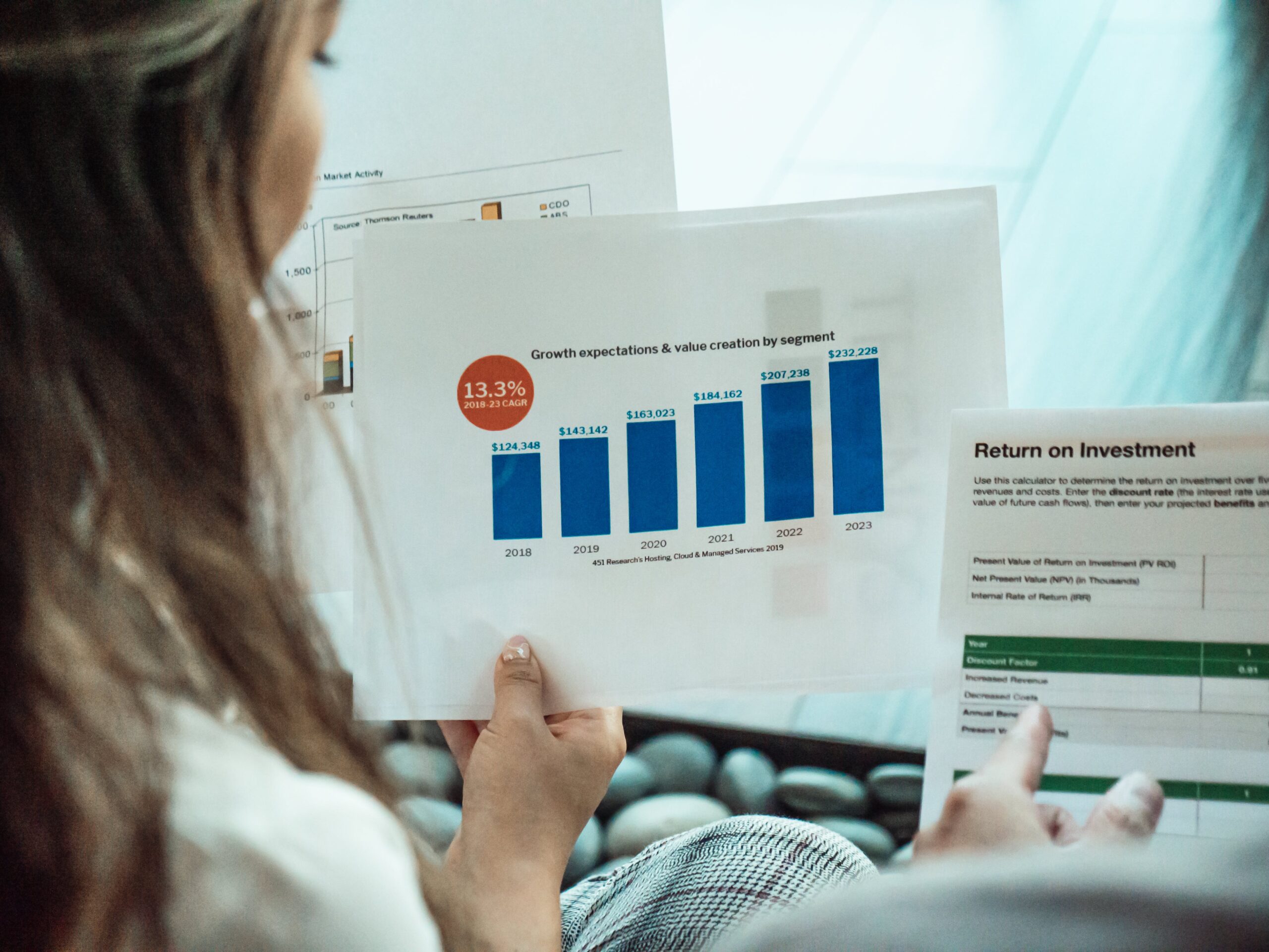 Woman holding graphs and charts measuring the Return on Investment ROI of digital marketing