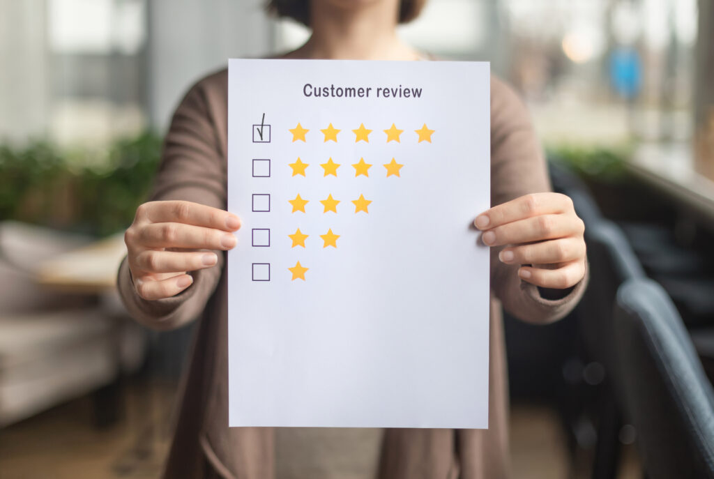 Satisfaction concept. Woman choosing with tick five star rating on paper sheet, blurred background and related to reputation management